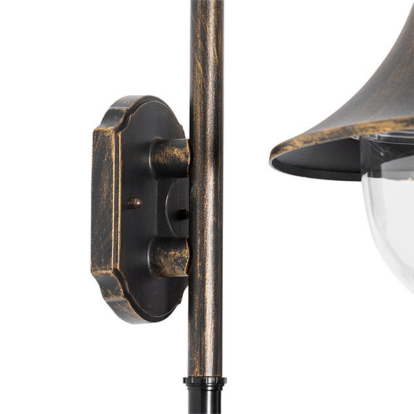 Detailansicht einer Wandhalterung für eine Außenwandleuchte aus Metall in Schwarz-Gold mit Lampenschirm und Klarglas.