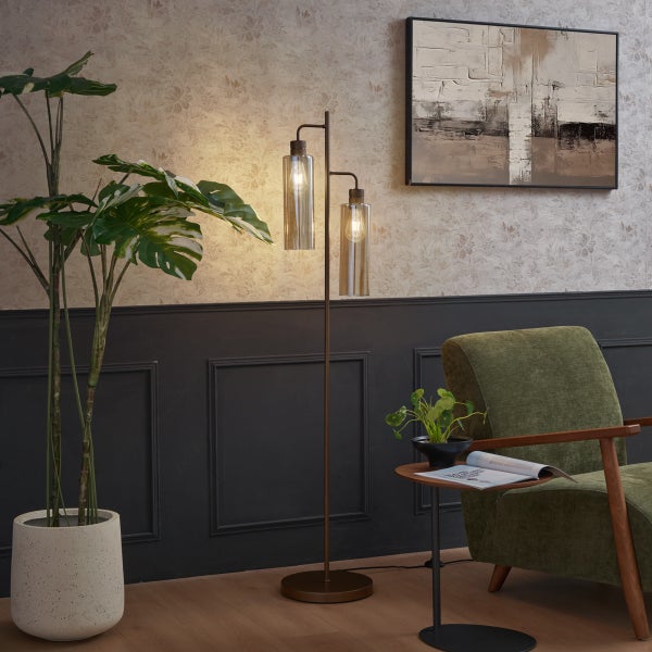 Wohnzimmer mit Stehlampe, Sessel und Zimmerpflanze