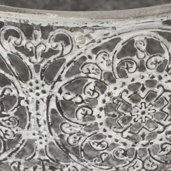 Detailansicht eines filigranen Metallmusters im Antik-Stil für Gartenmöbel.