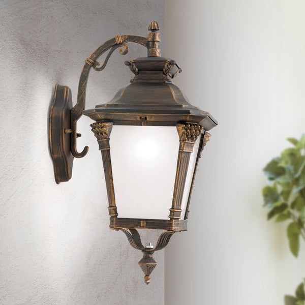 Klassische Außenwandleuchte im Laternendesign mit antikem Finish und geschwungener Wandhalterung.