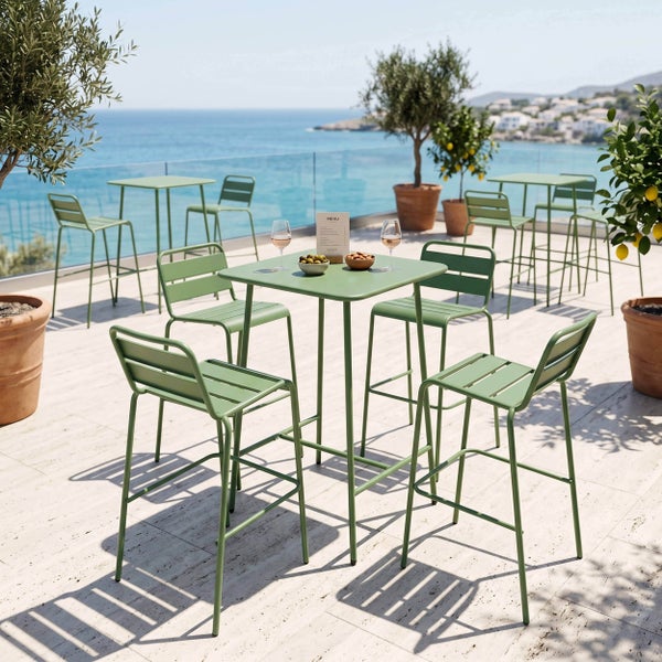 Moderne grüne Metall-Bargarnitur mit Hochtischen und Barhockern auf einer sonnigen Terrasse mit Meerblick und Topfpflanzen.