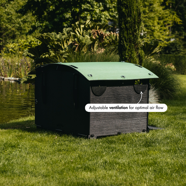 Mähroboter-Garage mit verstellbarer Belüftungsklappe für optimalen Luftstrom im Garten.