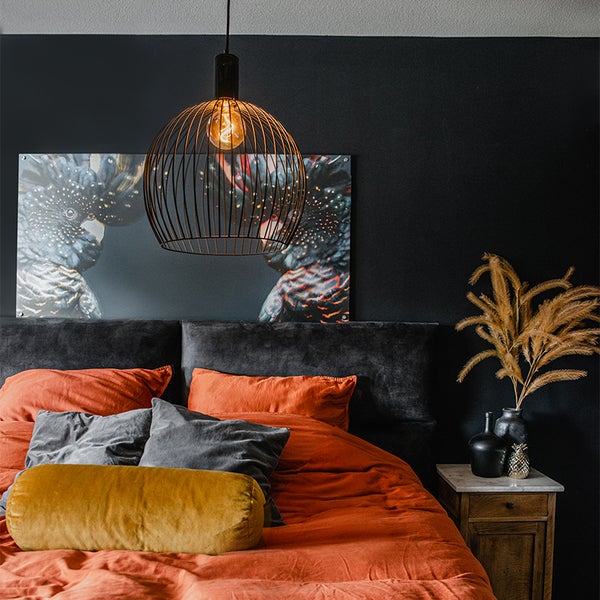 Schlafzimmer mit Bett, Nachttisch, Hängelampe und Wandbild