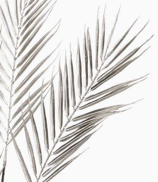 Zwei künstliche Palmblätter in Silber für dekorative Zwecke.