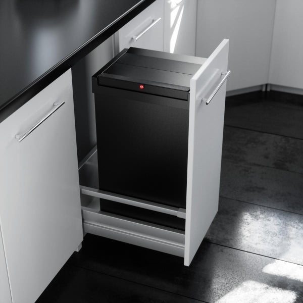 Schwarzer Einbau-Abfalleimer in einer weißen Küchenschublade.