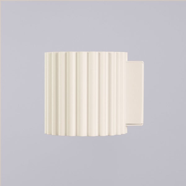 Moderne Wandleuchte mit geriffelter Oberfläche und rechteckiger Wandhalterung.