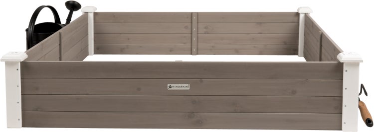 Hochbeet aus Holz mit Gießkanne und Gartenwerkzeug