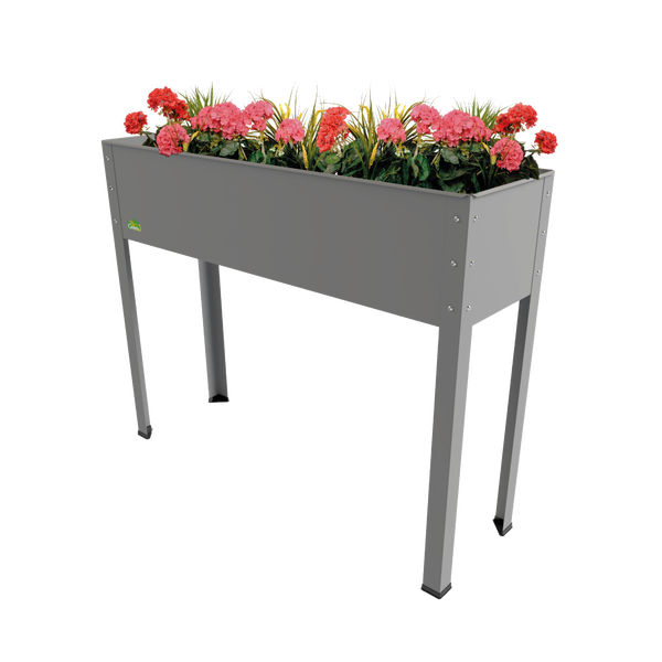 Graues Hochbeet aus Metall auf vier Beinen, bepflanzt mit rosa und roten Blumen.