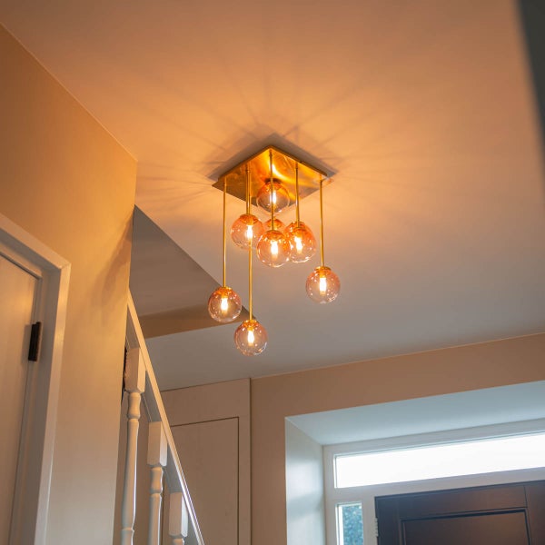 Deckenleuchte mit mehreren Glaskugeln und Metallstruktur im Innenraum