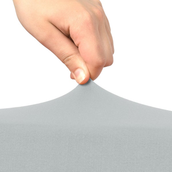 Eine Hand dehnt einen grauen Möbelbezug.