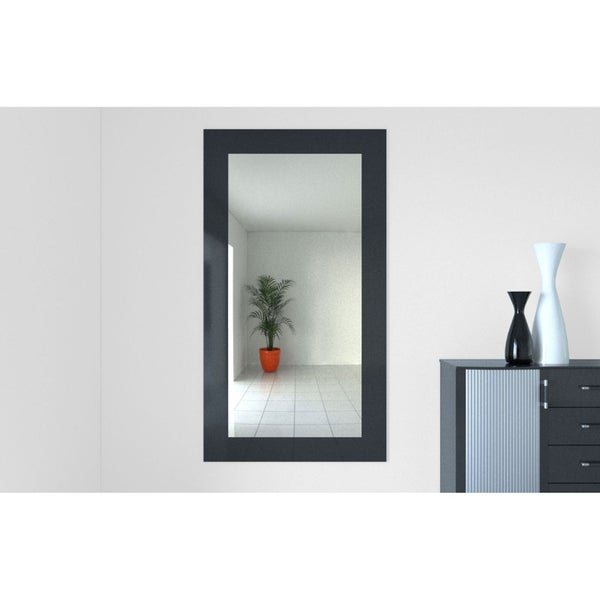Rechteckiger Spiegel mit dunklem Rahmen in einem Raum
