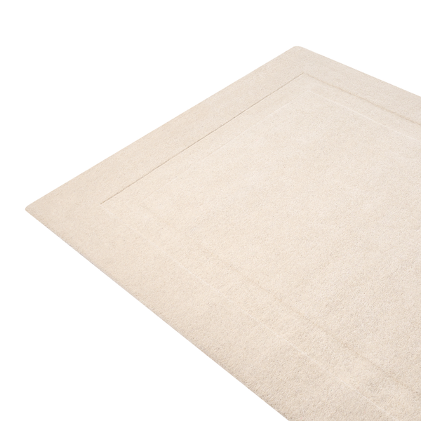 Beige Badematte mit weicher Oberfläche und geprägtem Rand.