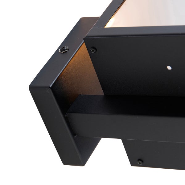 Nahaufnahme einer modernen schwarzen Wandleuchte aus Metall für den Außenbereich mit eckigem Gehäuse.