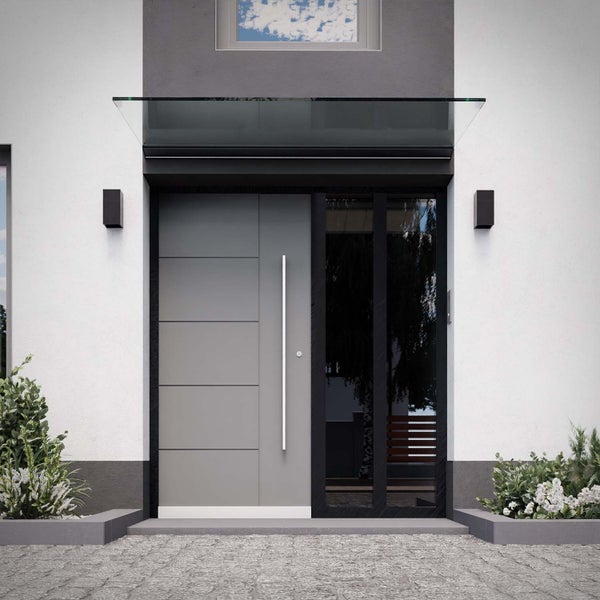 Moderne graue Haustür mit langem Stangengriff und Seitenteil aus Glas, darüber ein Glasvordach an einer weißen Fassade mit Außenleuchten.