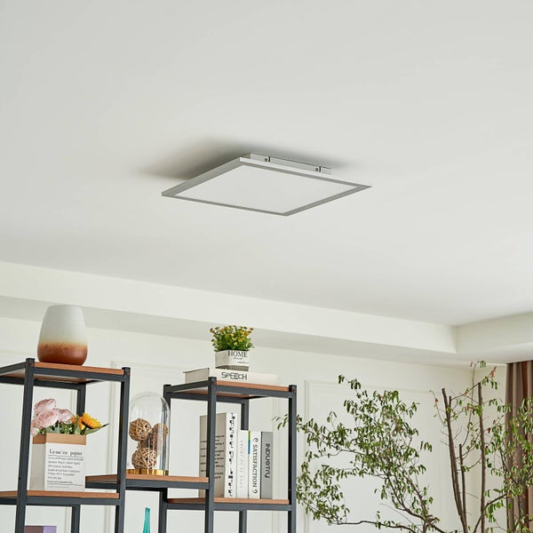 Quadratische LED-Deckenleuchte mit silbernem Rahmen montiert an der Decke über einem Regal mit Pflanzen und Dekoration.