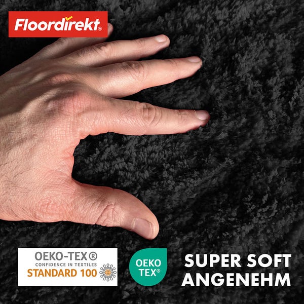 Nahaufnahme eines schwarzen Teppichs mit Hand und Logos von Floor direkt und OEKO-TEX Standard 100