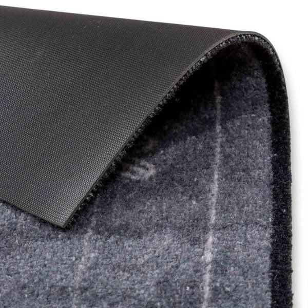 Detailaufnahme eines Teppichs mit Textiloberfläche und Gummiunterseite