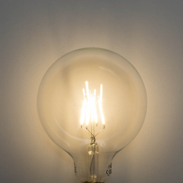 Leuchtendes LED-Filament-Leuchtmittel in Globusform aus klarem Glas.