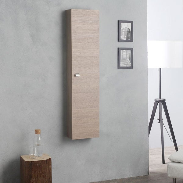 Wandhängender Bad-Hochschrank in heller Eichenholzoptik an einer grauen Wand in einem modern eingerichteten Raum.