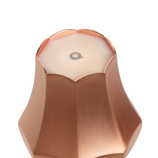 Nahaufnahme eines kupferfarbenen Armaturengriffs mit lichtdurchlässiger Oberseite und kreisförmigem Symbol.