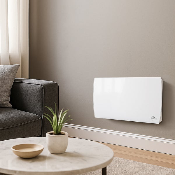 Flacher elektrischer Wandheizkörper in Weiß in einem modernen, hellen Wohnzimmer neben einem grauen Sofa und einem Marmortisch.
