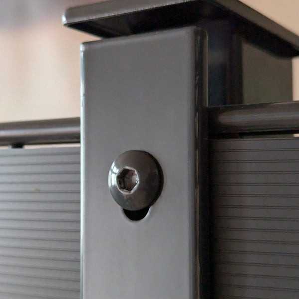 Detailansicht eines Metallzauns mit Schraube