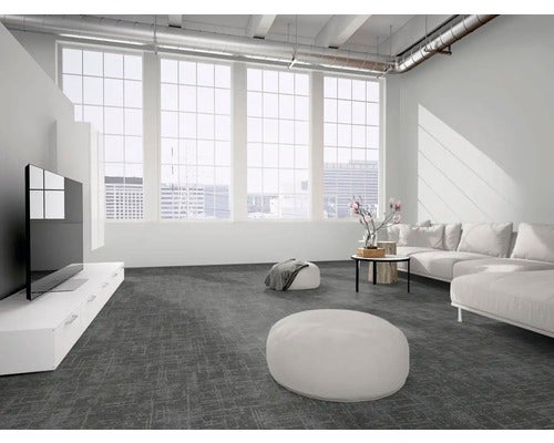 Geräumiges, helles Wohnzimmer im industriellen Loft-Stil mit grauem texturiertem Teppichboden, großen Fenstern, weißem Sofa und Fernsehschrank.