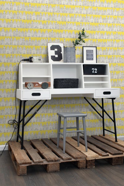 Dekoratives Arbeitszimmer mit Schreibtisch auf einer Palette und gelber Tapete