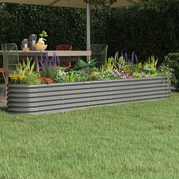 Bepflanztes Hochbeet aus gewelltem Metall auf einer Rasenfläche im Garten.