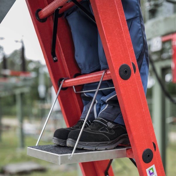Person auf einer roten Leiter mit einer Plattform.