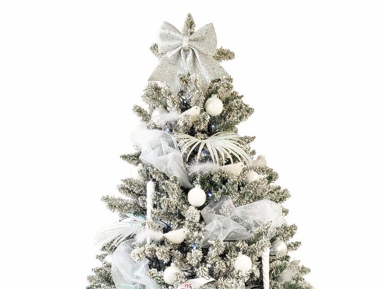 Weihnachtsbaum mit Kunstschnee Dekoration, geschmückt mit Kugeln, Schleifen und Vögeln als festliche Dekoration für das Weihnachtsfest.
