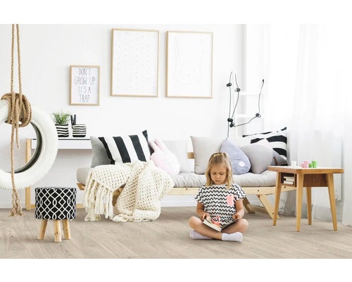 Kinderzimmer mit Reifen-Schaukel, Sofa, Hocker und spielendem Kind