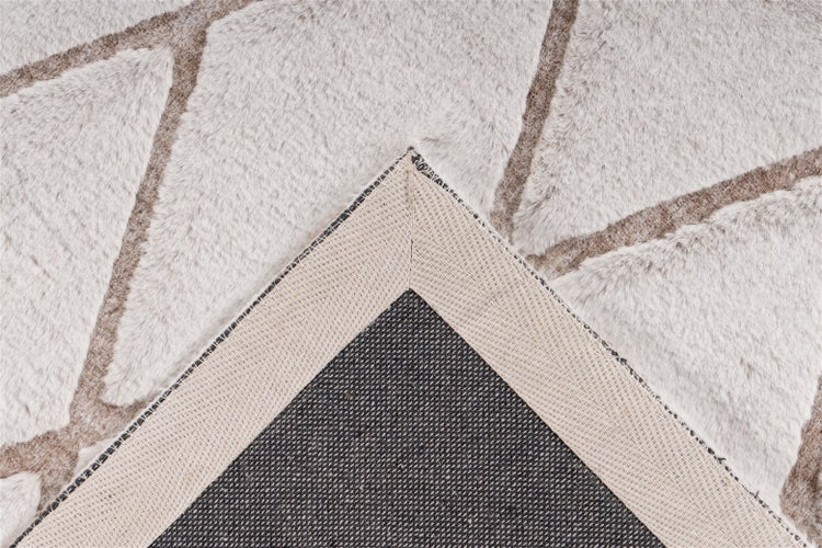 Nahaufnahme eines Teppichs mit geometrischem Muster aus Plüsch und der rutschfesten Rückseite.