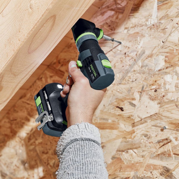 Eine Person schraubt mit einem Festool Akku-Bohrschrauber eine Schraube in ein Holzbrett.