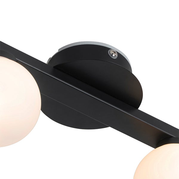 Detailansicht einer schwarzen Leuchte aus Metall mit runden Schirmen aus weißem Glas und runder Halterung.