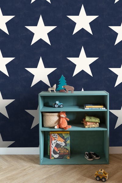 Kinderzimmer mit blau-weisser Sternentapete und Regal mit Spielsachen