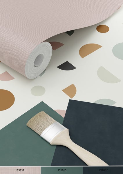 Tapetenrolle mit geometrischen Formen und Farbmustern sowie einem Pinsel