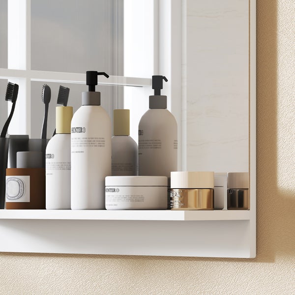 Weißer Badezimmerspiegel mit Ablage und verschiedenen Pflegeprodukten wie Pumpflaschen, Zahnbürsten und Cremedosen.
