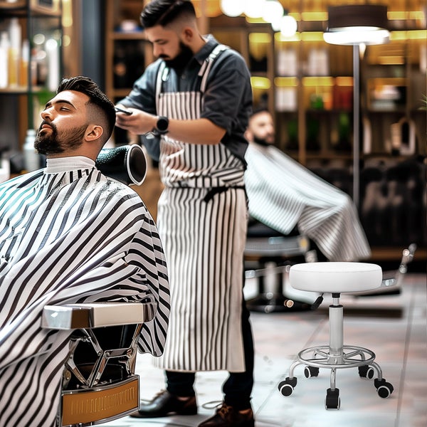 Ein moderner, höhenverstellbarer Arbeitshocker mit Rollen und einem runden Sitzpolster, positioniert in einem professionellen Barbershop.