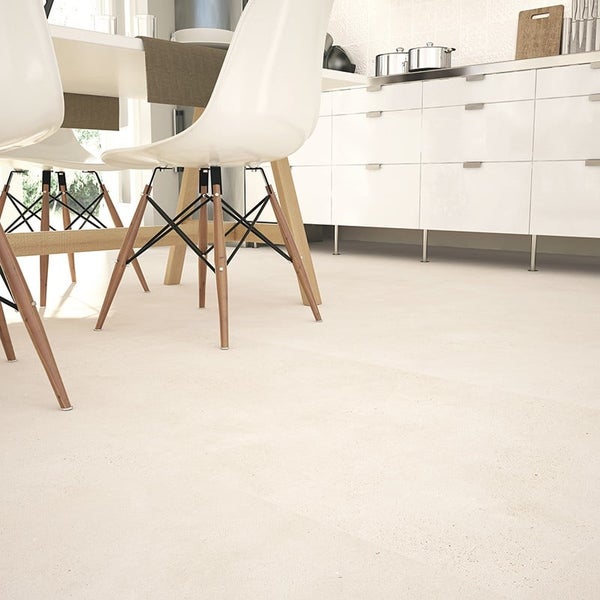 Esszimmer mit großformatigen Fliesen im Betonoptik-Design, moderner Holztisch mit gedeckten Plätzen und weißen Stühlen in heller Umgebung.