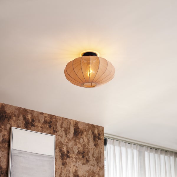 Deckenleuchte mit ovalem Schirm aus Netzgewebe und warm leuchtender Filamentlampe in einem hellen Raum.