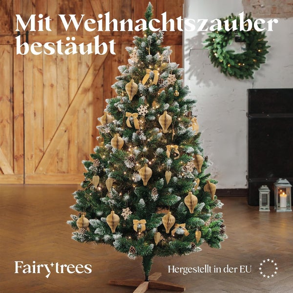 Geschmückter künstlicher Weihnachtsbaum von Fairy Trees mit Schneebedeckung und Beleuchtung in einem weihnachtlich dekorierten Wohnraum