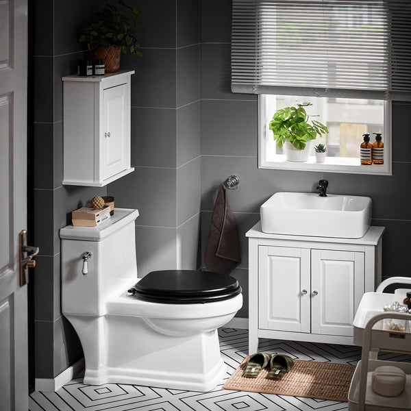 Badezimmer mit Toilette, Waschbeckenunterschrank, Hängeschrank und Fenster