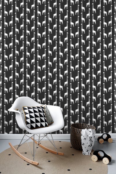 Szene mit einem weißen Schaukelstuhl, einem Korb und einem Teppich vor einer Tapete mit Giraffenmuster.