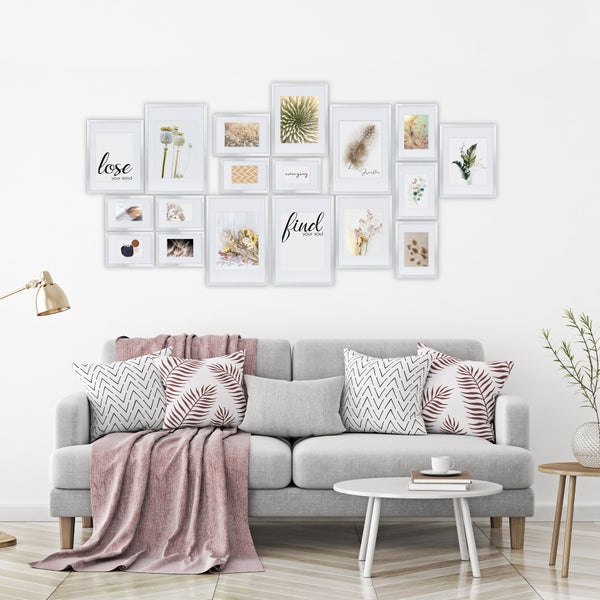 Wohnzimmer mit Bilderrahmen, Sofa und Kissen an der Wand