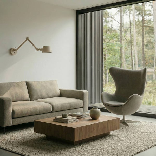 Wohnzimmer mit Sofa, Sessel, Couchtisch und Wandlampe