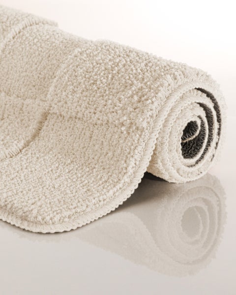 Gerollte Badematte mit weichem Schlingenflor und rutschhemmender Rückseite.