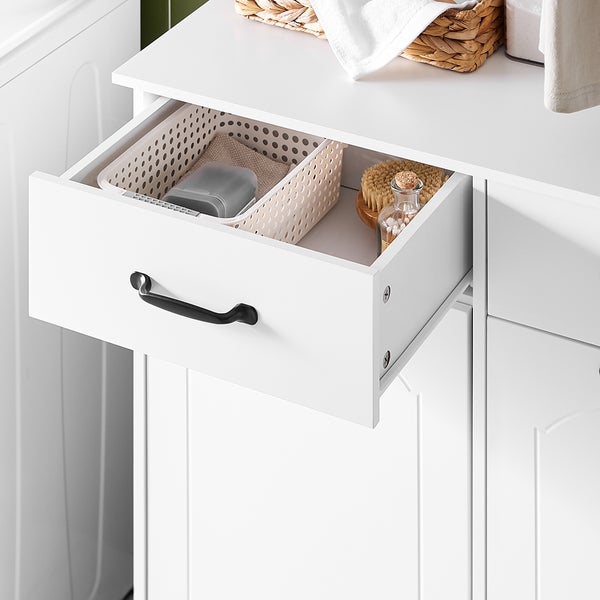 Offene Schublade eines weißen Badezimmerschranks mit verschiedenen Badutensilien