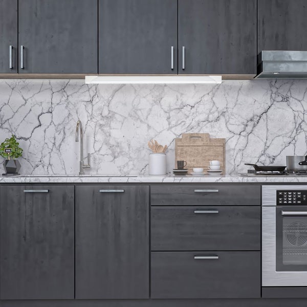 Moderne Küche mit dunklen Schränken, Marmorrückwand und einer hellen LED-Unterbauleuchte über der Arbeitsplatte und Spüle.