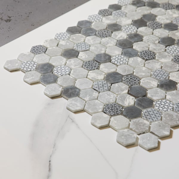 Sechseckige Mosaikfliesen in Grau- und Weißtönen mit verschiedenen Mustern.